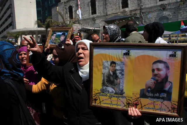 Palestinian women hold pictures of relatives during a protest calling for the release of Palestinian prisoners from Israeli jails, in the West Bank city of Nablus , Sunday, April 10, 2011. Israel currently holds about 8,...