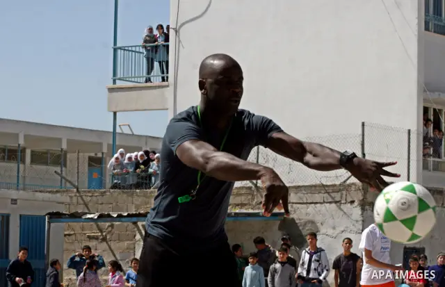 Former French soccer player Lilian Thuram visits a school in the West bank refugee camp of Kalandia, on 11 April 2011. Thuram is visiting the Palestinian territory in support of the education programme funded by France t...
