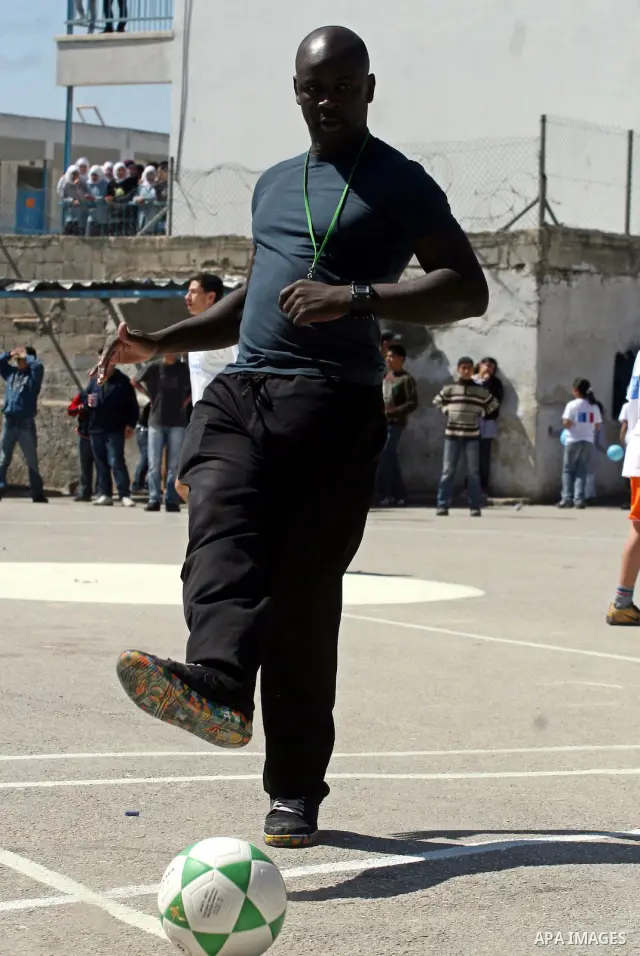 Former French soccer player Lilian Thuram visits a school in the West bank refugee camp of Kalandia, on 11 April 2011. Thuram is visiting the Palestinian territory in support of the education programme funded by France t...