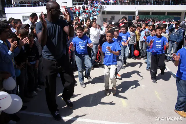 Former French soccer player Lilian Thuram visits a school in the West bank refugee camp of Kalandia, on 11 April 2011. Thuram is visiting the Palestinian territory in support of the education programme funded by France t...