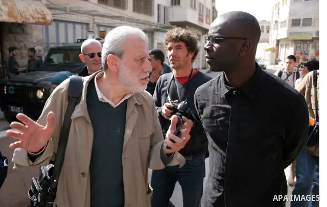 Former French football player Lilian Thuram (R) looks on during a visit to the divided city of Hebron, in the Israeli-occupied West Bank, on April 13, 2011. Thuram is visiting the Palestinian territories in support of th...