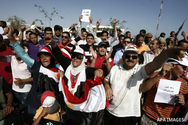 Egyptian protesters shout slogans and wave the national flag outside the Sharm el Sheikh International Hospital where the ousted Egyptian leader Hosni Mubarak was admitted after suffering medical complications during que...