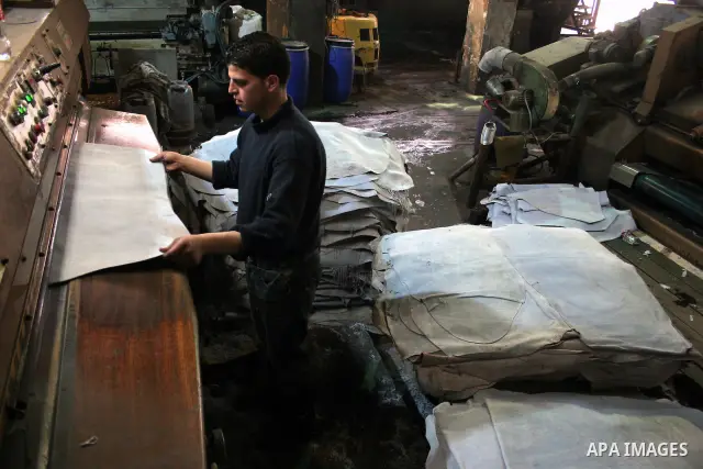 A Palestinian holds a piece of leather, some meant to be transported to Israel, Europe unions and Gaza strip at Palestine Tanning Factory in the West Bank city of Hebron April 14, 2011. Cattle owners in Hebron, the West...