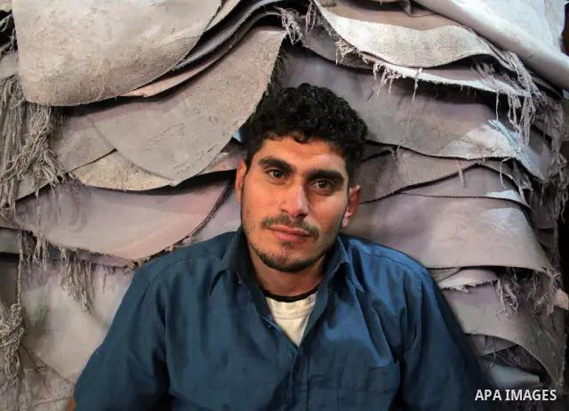 A Palestinian holds a piece of leather, some meant to be transported to Israel, Europe unions and Gaza strip at Palestine Tanning Factory in the West Bank city of Hebron April 14, 2011. Cattle owners in Hebron, the West...