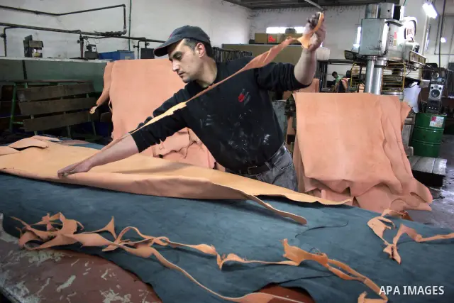 A Palestinian holds a piece of leather, some meant to be transported to Israel, Europe unions and Gaza strip at Palestine Tanning Factory in the West Bank city of Hebron April 14, 2011. Cattle owners in Hebron, the West...