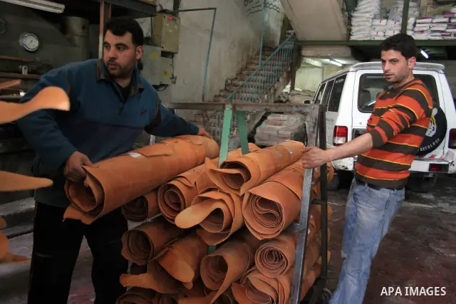 A Palestinian holds a piece of leather, some meant to be transported to Israel, Europe unions and Gaza strip at Palestine Tanning Factory in the West Bank city of Hebron April 14, 2011. Cattle owners in Hebron, the West...