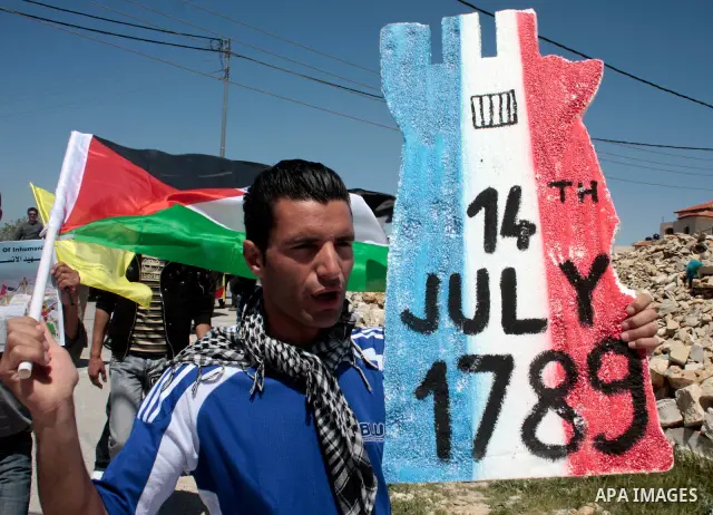 A protester holds a placard depicting the Italian flag and the birth date of Vittorio Arrigoni after kidnapping him in Gaza during a demonstration against Israel's controversial separation barrier in the West Bank villag...