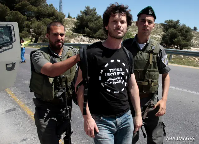 Israeli soldiers arrest a protester during a demonstration against Israel's controversial separation barrier and in support with Vittorio Arrigoni after kidnapping him in Gaza, in the West Bank village of Maasarah, near...
