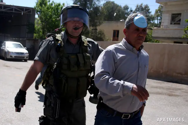 An Israeli soldier detains a demonstrator during a protest by Palestinian and foreign demonstrators against the expropriation of land to expand the Jewish settlement of Halmish, in the Palestinian village of Nabi Saleh,...