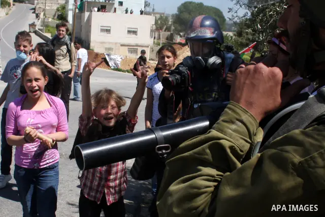 Palestinian boys take part in a protest against the expropriation of land to expand the Jewish settlement of Halmish, in the Palestinian village of Nabi Saleh, in the Israeli-occupied West Bank, on April 15, 2011. Photo...