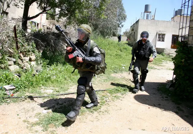 Israeli soldiers take position during a protest by Palestinian and foreign demonstrators against the expropriation of land to expand the Jewish settlement of Halmish, in the Palestinian village of Nabi Saleh, in the Isra...
