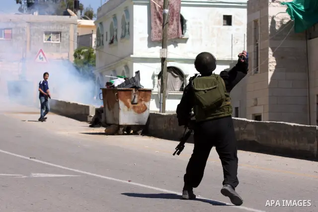Palestinian and foreign demonstrators run away from tear gas fired by Israeli soldiers to disperse a protest against the expropriation of land to expand the Jewish settlement of Halmish, in the Palestinian village of Nab...