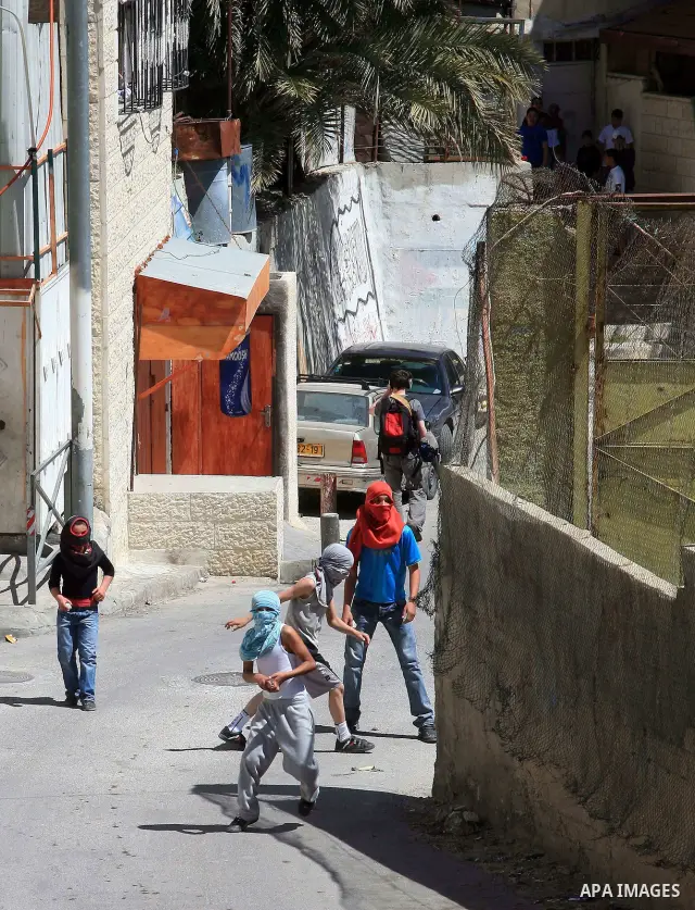 Masked Palestinian youths hurl toward Israeli riot policemen (unseen) in the east Jerusalem neighborhood of Silwan on April 15, 2011 following brief clashes between police and stone throwers. Photo by Sliman Khader