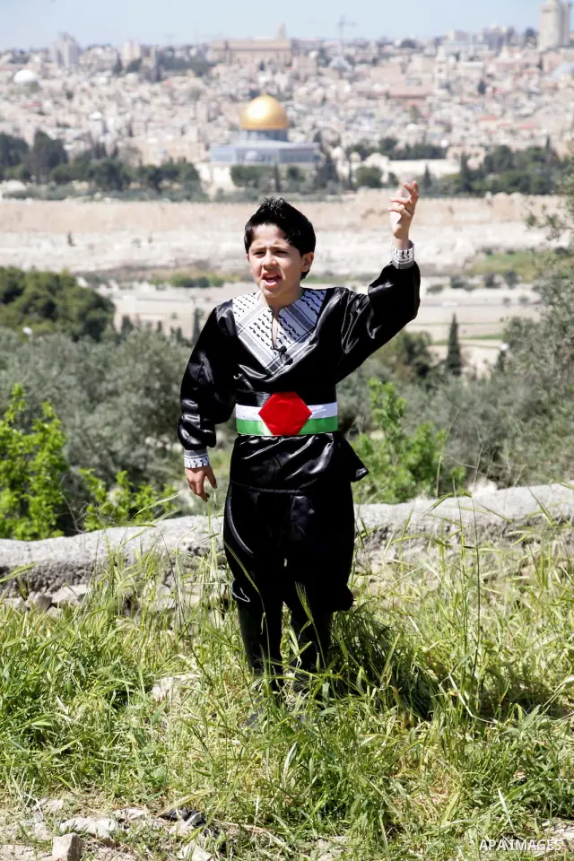 The Palestinian child Issam Bashiti, who was participated in the program Arab's got talent, delivers poetry in front of media in Jerusalem's old city on April 15,2011. The Dome of the Rock shown in the background. Photo...