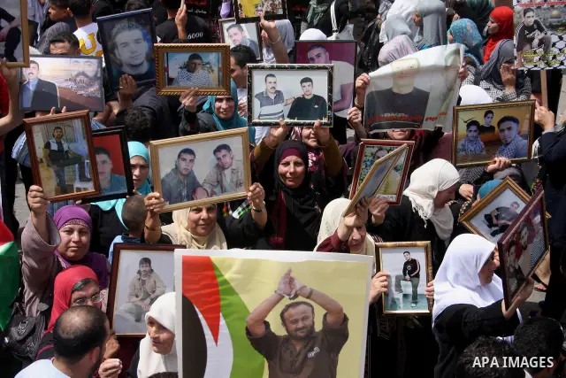 Palestinians hold pictures of their relatives who are imprisoned in an Israeli jail during a protest for the Prisoners Day which will be held on Sunday, in the West Bank city of Ramallah April 16, 2011. Photo by Issam Ri...