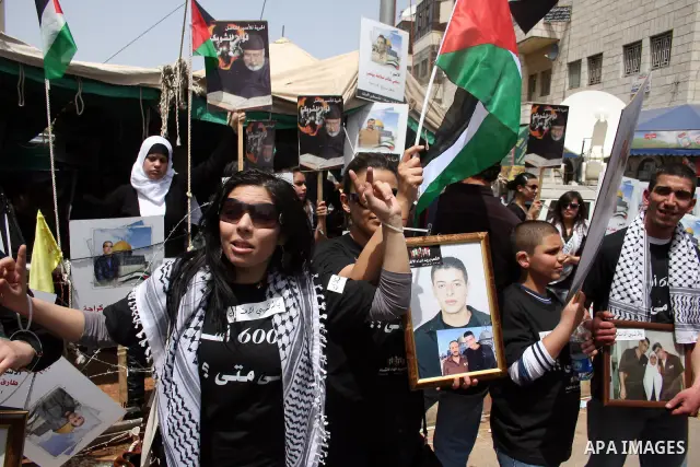 Palestinians hold pictures of their relatives who are imprisoned in an Israeli jail during a protest for the Prisoners Day which will be held on Sunday, in the West Bank city of Ramallah April 16, 2011. Photo by Issam Ri...