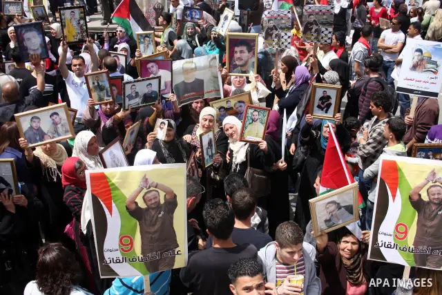 Palestinians hold pictures of their relatives who are imprisoned in an Israeli jail during a protest for the Prisoners Day which will be held on Sunday, in the West Bank city of Ramallah April 16, 2011. Photo by Issam Ri...