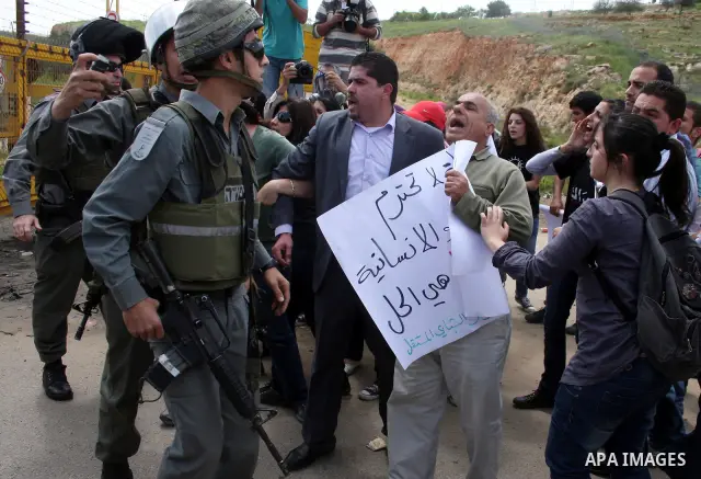 Palestinians and foreigners argue with Israeli soldiers during a protest outside Ofer prison, near the West Bank city of Ramallah, April 17, 2011, calling for the release of Palestinian prisoners from Israeli jails. Apri...