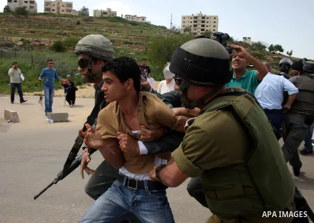 Israeli soldiers detain a Palestinian youth during a protest outside Ofer prison, near the West Bank city of Ramallah, April 17, 2011, calling for the release of Palestinian prisoners from Israeli jails. April 17 marks P...