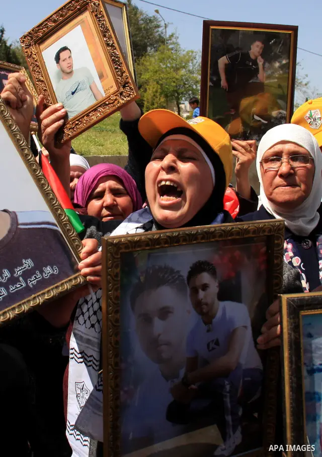 Palestinian women hold photographs of relatives jailed in Israel, during a protest to mark Prisoner's Day in the West Bank city of Nablus, Sunday, April 17, 2011. Some 5,500 Palestinians are held in Israeli prisons accor...