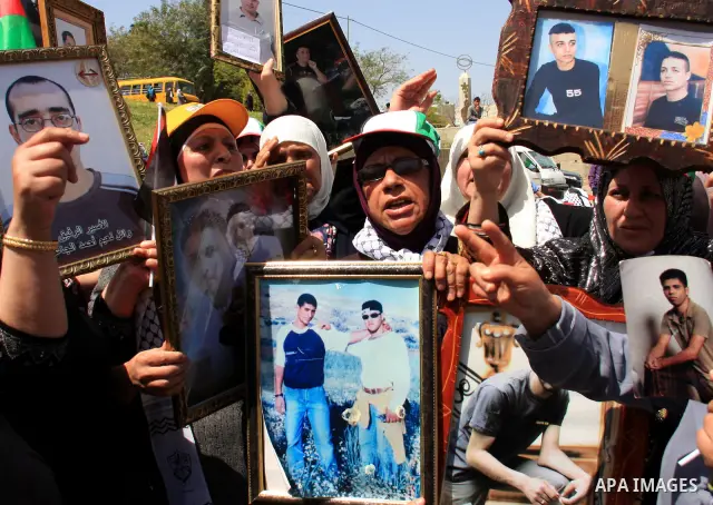 Palestinian women hold photographs of relatives jailed in Israel, during a protest to mark Prisoner's Day in the West Bank city of Nablus, Sunday, April 17, 2011. Some 5,500 Palestinians are held in Israeli prisons accor...