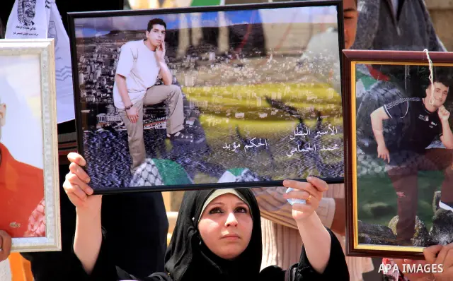 Palestinian women hold photographs of relatives jailed in Israel, during a protest to mark Prisoner's Day in the West Bank city of Nablus, Sunday, April 17, 2011. Some 5,500 Palestinians are held in Israeli prisons accor...