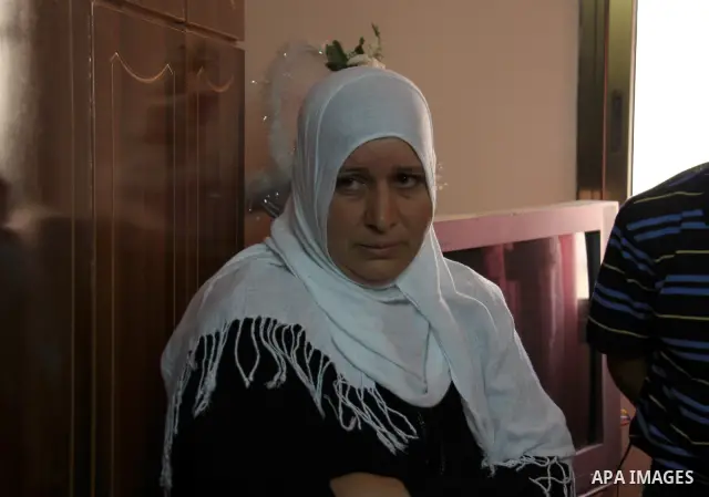 Palestinian Shama Awad, mother of Amjad Awad, suspected in a stabbing attack that killed Jewish settler family, talks to journalists at her home in the West Bank village of Awarta near Nablus, Sunday, April 17, 2011. Isr...