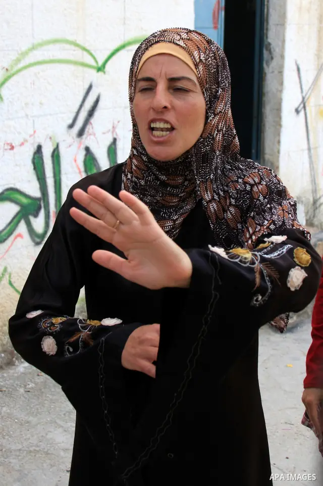 Palestinian Nouf Awad, mother of Hakim Awad, suspected in a stabbing attack that killed Jewish settler family, talks to journalists at her house in the West Bank village of Awarta near Nablus, Sunday, April 17, 2011. Isr...