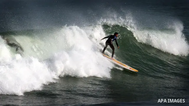 In this photo taken on April 14,2011, a Palestinian youth surf in the Mediterranean Sea off the coast of Gaza City, as a hot weather hits Gaza Strip. Photo by Mahmoud Nassar