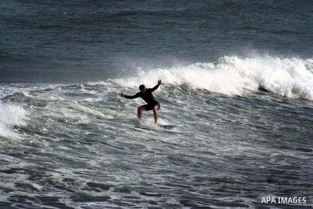 In this photo taken on April 14,2011, a Palestinian youth surf in the Mediterranean Sea off the coast of Gaza City, as a hot weather hits Gaza Strip. Photo by Mahmoud Nassar