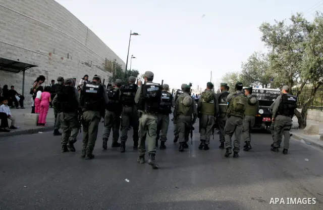 Israeli troops stand guard as Christian pilgrims take part the Palm Sunday procession from Mt. Olives into Jerusalem's old city on April 17, 2011, marking the triumphant return of Jesus Christ to Jerusalem when a cheerin...