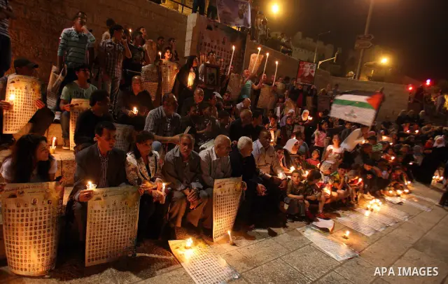 Palestinians light candles during a protest to mark Prisoner's Day in front Damascus Gate in Jerusalem's old city, Sunday, April 17, 2011. Some 5,500 Palestinians are held in Israeli prisons according to figures compiled...