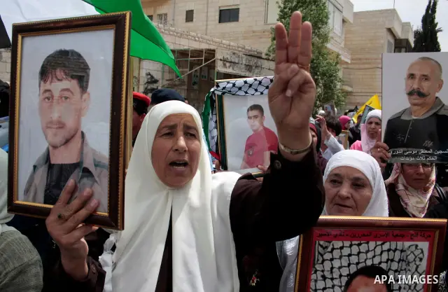 Palestinians hold up a photo of jailed family members as they take part in a rally, one of several taking place across the Israeli occupied West Bank and Gaza Strip, calling for the release of Palestinians being held in...