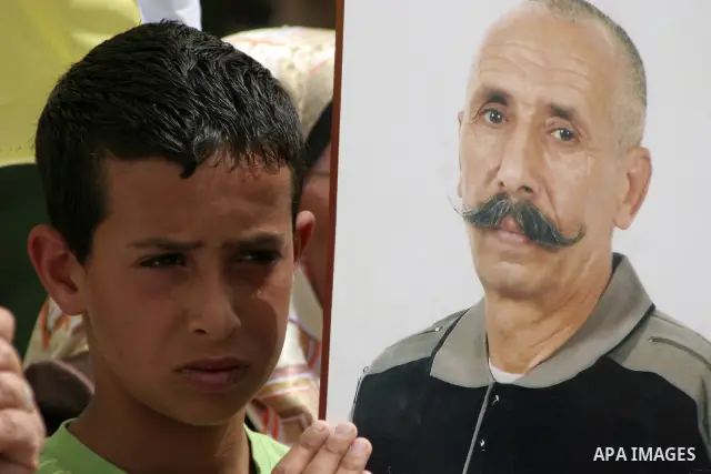 Palestinians hold up a photo of jailed family members as they take part in a rally, one of several taking place across the Israeli occupied West Bank and Gaza Strip, calling for the release of Palestinians being held in...