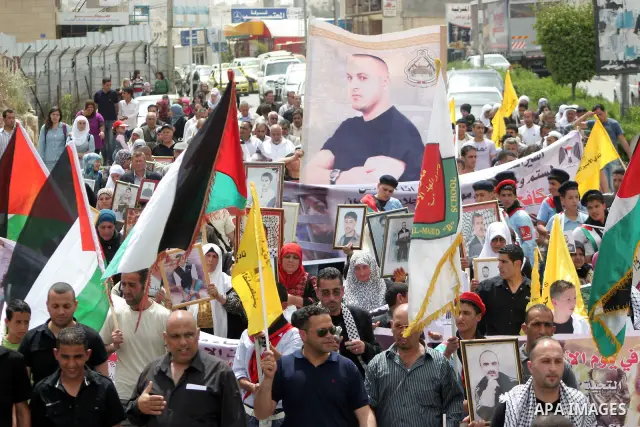 Palestinians hold up a photo of jailed family members as they take part in a rally, one of several taking place across the Israeli occupied West Bank and Gaza Strip, calling for the release of Palestinians being held in...