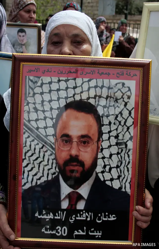 Palestinians hold up a photo of jailed family members as they take part in a rally, one of several taking place across the Israeli occupied West Bank and Gaza Strip, calling for the release of Palestinians being held in...