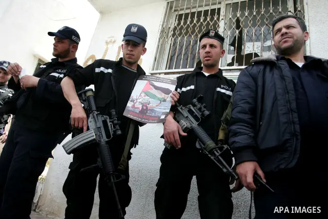 Members of Hamas' security forces hold back Palestinians reacting after the coffin of Italian activist Vittorio Arrigoni was taken out of al-Shifa hospital in Gaza City April 18, 2011. Friends of the Italian activist Arr...