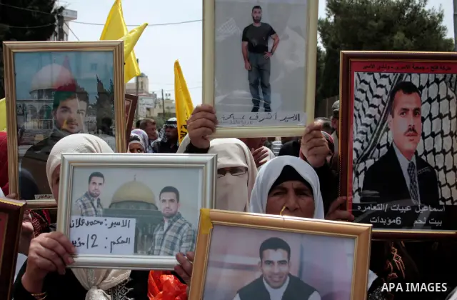 Palestinians hold up a photo of jailed family members as they take part in a rally, one of several taking place across the Israeli occupied West Bank and Gaza Strip, calling for the release of Palestinians being held in...
