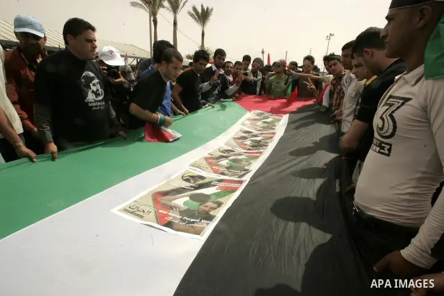 Palestinians and foreigners mourn during the "state funeral" of Italian activist Vittorio Arrigoni in Rafah, southern Gaza Strip, on April 18, 2011 before the transferring of his body to Egypt via the Rafah border crossi...