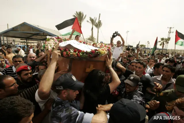 Palestinians and foreigners mourn during the "state funeral" of Italian activist Vittorio Arrigoni in Rafah, southern Gaza Strip, on April 18, 2011 before the transferring of his body to Egypt via the Rafah border crossi...