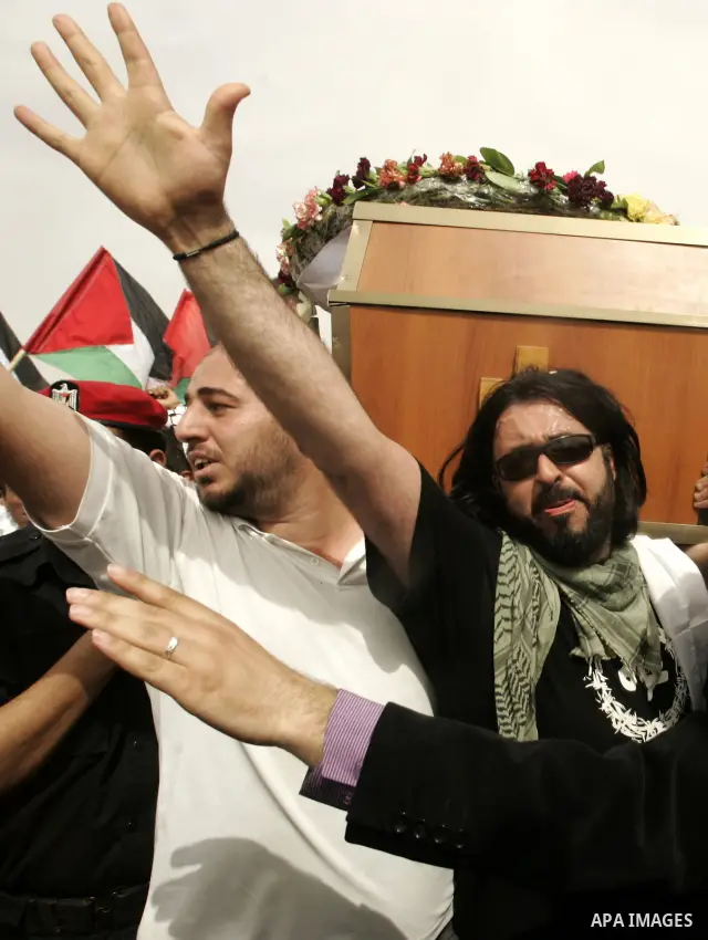 Palestinians and foreigners mourn during the "state funeral" of Italian activist Vittorio Arrigoni in Rafah, southern Gaza Strip, on April 18, 2011 before the transferring of his body to Egypt via the Rafah border crossi...