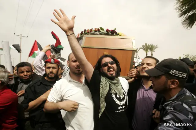Palestinians and foreigners mourn during the "state funeral" of Italian activist Vittorio Arrigoni in Rafah, southern Gaza Strip, on April 18, 2011 before the transferring of his body to Egypt via the Rafah border crossi...