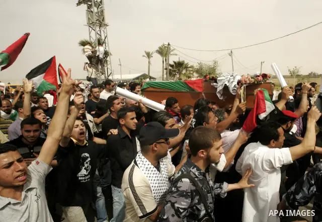 Palestinians and foreigners mourn during the "state funeral" of Italian activist Vittorio Arrigoni in Rafah, southern Gaza Strip, on April 18, 2011 before the transferring of his body to Egypt via the Rafah border crossi...