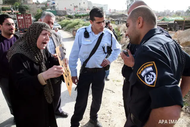 An Israeli policeman prevent Palestinians to lay a placard printed with Arabic name of a street during the project of Arabization of the streets in the neighborhood of Sheikh Jarrah in East Jerusalem on April 19,2011. Ph...