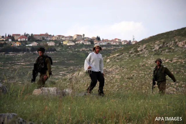 A Jewish settler from the Har Bracha settlement holds stones as he readies to lob them at local Palestinian villagers during clashes close to the Palestinian village of Burin in the Israeli occupied West bank on April 19...