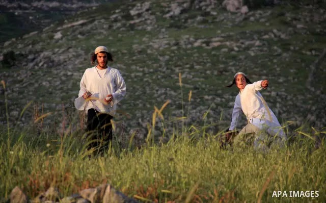 A Jewish settler from the Har Bracha settlement holds stones as he readies to lob them at local Palestinian villagers during clashes close to the Palestinian village of Burin in the Israeli occupied West bank on April 19...