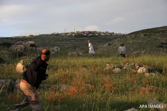 A Jewish settler from the Har Bracha settlement holds stones as he readies to lob them at local Palestinian villagers during clashes close to the Palestinian village of Burin in the Israeli occupied West bank on April 19...