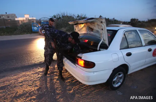 Members of Hamas' security forces search a car near the scene where the main suspects in the killing of a pro-Palestinian Italian activist were killed at the Nuseirat refugee camp in the central Gaza Strip April 19, 2011...
