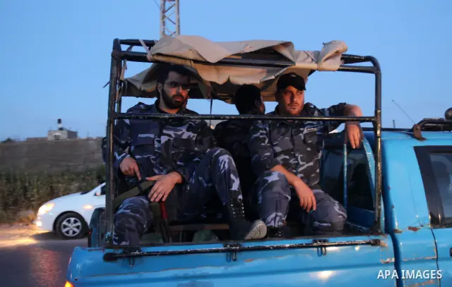 Members of Hamas' security forces search a car near the scene where the main suspects in the killing of a pro-Palestinian Italian activist were killed at the Nuseirat refugee camp in the central Gaza Strip April 19, 2011...
