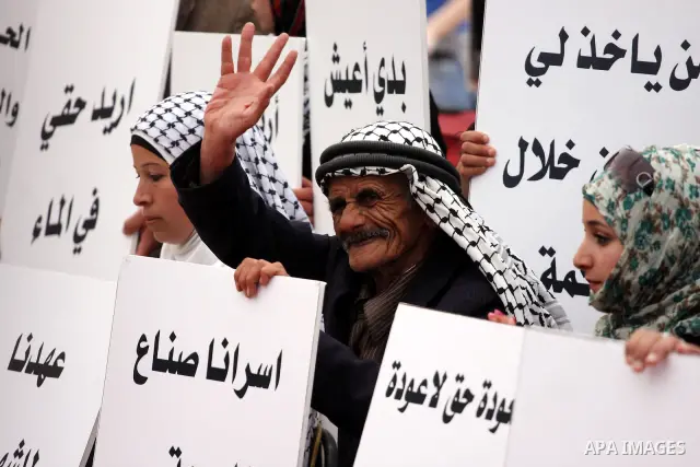 Palestinians hold up slogans during the opening ceremony of the 6th Bilin international conference for Palestinian Popular Resistance on April 20, 2011 in West Bank village of Bilin, near Ramallah. Fayyad called on the i...